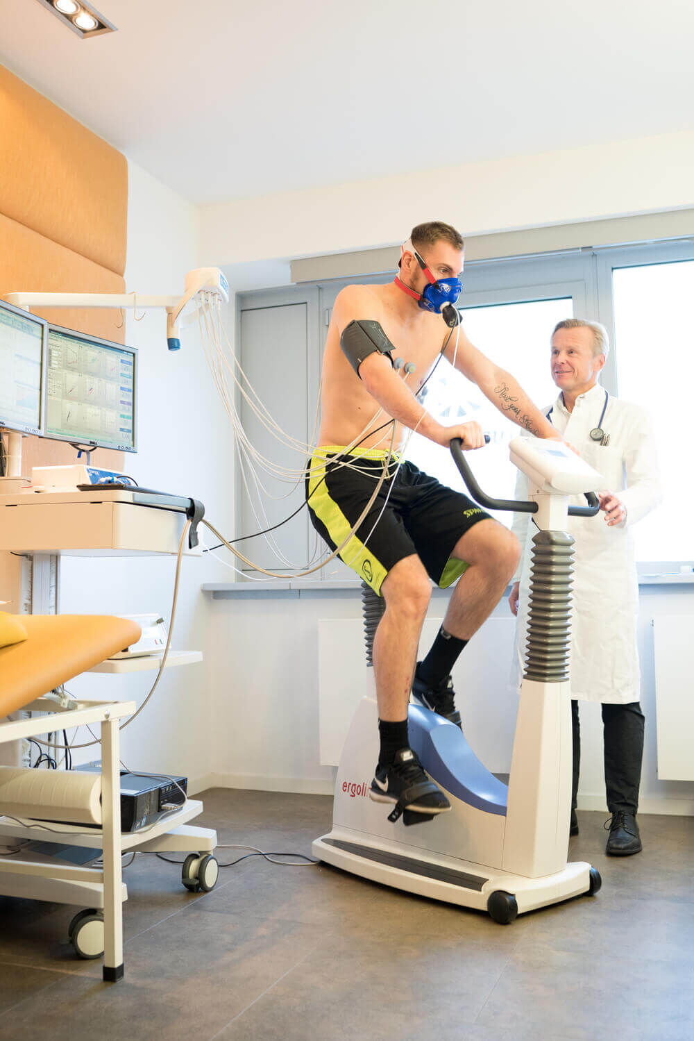 Facharzt für Kardiologie: Dr. med. Heidland begleitet den Patienten während dem Belastungs-EKG auf dem Fahrrad-Ergometer